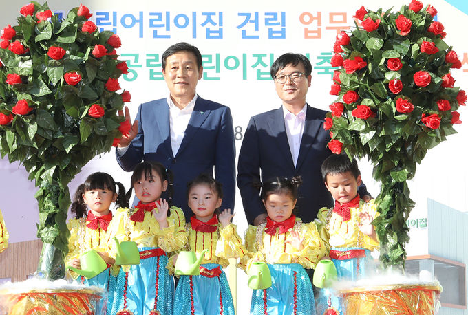 하나금융그룹은 지난 12일 오후 거제시와 함께 거제시 아주동에 위치한 국공립어린이집 건립 예정지에서 국공립어린이집 건립 지원을 위한 업무협약식 및 신축 기공식을 가졌다. 업무협약 후 김정태 하나금융그룹 회장(두번째 줄 왼쪽)과 변광용 거제시장(두번째 줄 오른쪽)이 행사에 어린이들과 기념 사진 촬영을 하고 있다.
