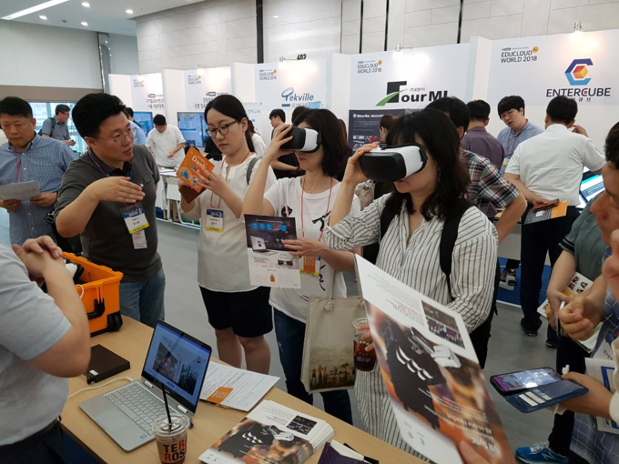 지난 14일 서울 삼성동 코엑스에서 열린 '에듀클라우드 월드 2018'에서 관람객들이 온페이스의 올인원 VR 헤드셋을 착용하고 기능을 체험하고 있다.