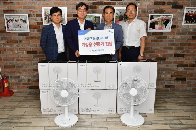 농협은행 이대훈 은행장(왼쪽 두 번째)과 임직원들이 지난 30일 서울 시립 서울역쪽방상담소를 방문해 가정용 선풍기 200대를 기증하고 기념촬영을 하고 있다.