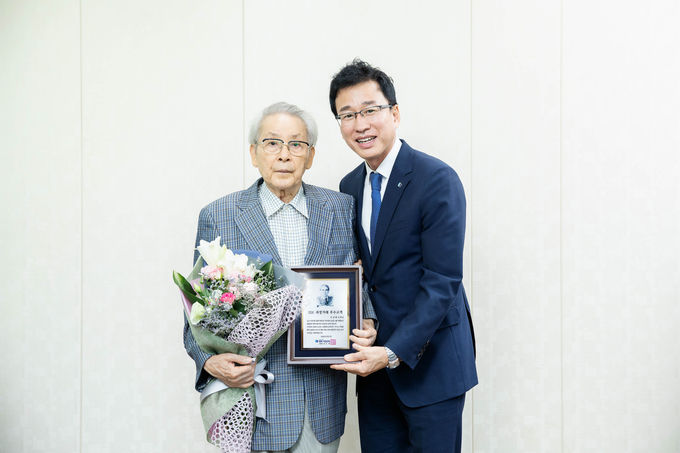지난 24일 기업은행 대구지점에서 배용덕 기업은행 개인고객그룹 부행장(오른쪽)이 이상학 고객에게 ‘IBK 최장거래 우수고객’ 감사패를 전달하고 기념촬영을 하고 있는 모습.