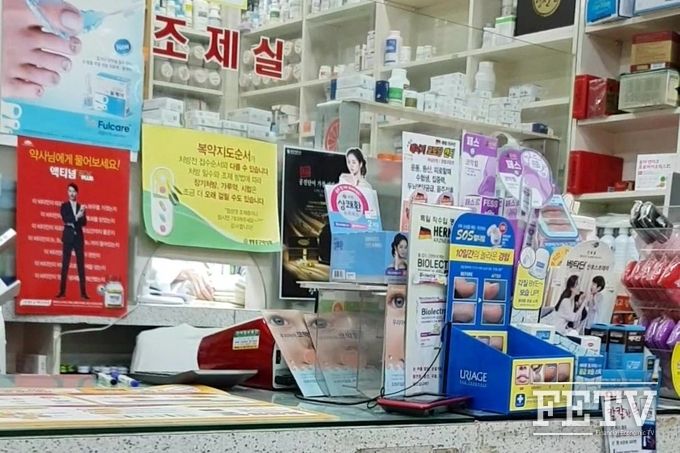 각종 의약품 광고 포스터로 조제실 내부가 보이지 않는 A약국