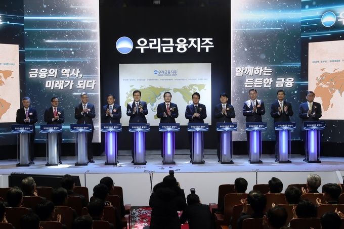 손태승 우리금융지주 회장 겸 우리은행장(왼쪽 여섯번째)이 14일 오전 서울 중구 우리은행 본점에서 열린 우리금융지주 출범식에서 현판 점등식을 마친 뒤 기념촬영 하고 있다. (사진 왼쪽부터 노성태 사외이사, 이순우 전 회장, 황영기 전 회장, 위성백 예금보험공사 사장, 최종구 금융위원회 위원장, 손태승 우리금융지주 회장, 민병두 정무위원회 위원장, 유광열 금융감독원 수석부원장, 김태영 은행연합회 회장, 차남규 한화생명 부회장, 정몽원 한라그룹 회장)