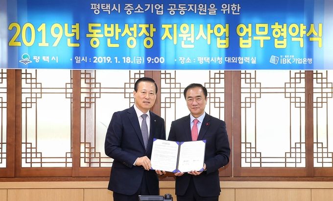 김도진 기업은행장(왼쪽)과 정장선 평택시장이 18일 평택시청에서 업무협약식을 마치고 기념촬영하는 모습.
