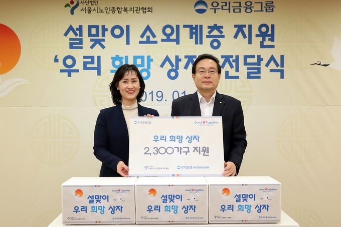 우리은행은 지난 18일 서울 중구 본점에서 소외계층을 위해 ‘우리희망상자’ 2300개를 제작해 전달하는 행사를 가졌다. 손태승 우리금융그룹 회장(사진 오른쪽)이 성미선 서울시 노인종합복지관협회장과 기념 촬영을 하고 있다.
