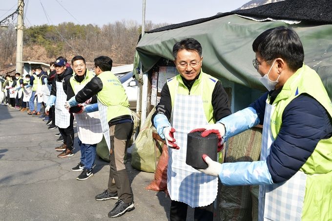김인태 마케팅부문 부행장(오른쪽 두 번째)과 1004봉사단은 30일 중계동 백사마을을 찾아 독거 어르신들 댁에 연탄을 배달했다.