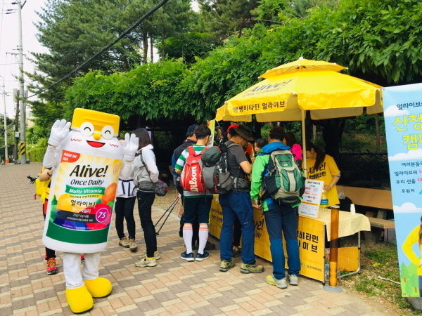 사진=네츄럴라이프 ‘쌩쌩비타민 얼라이브’가 등산객들에게 쓰레기 수거용 생분해 친환경 봉투를 나누어 주고 있다.
