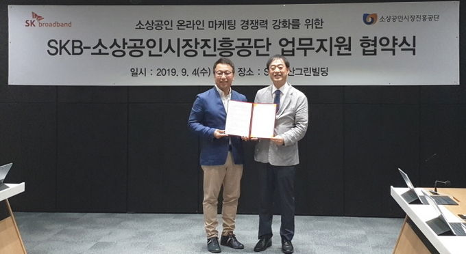 김혁(왼쪽) SK브로드밴드 세그먼트트라이브장과 김성근 소상공인시장진흥공단 본부장이 소상공인 지원방안 업무 협약식을 체결한 뒤 사진촬영 하고 있다. 사진=SK브로드밴드