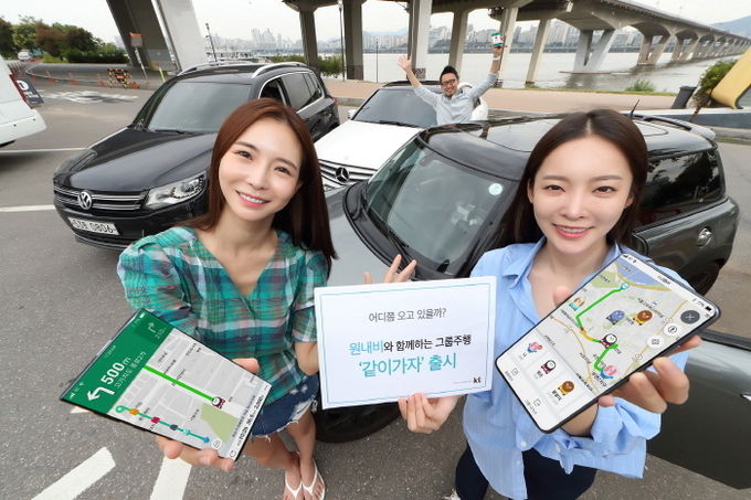 KT 모델들이 각자의 현재 위치 및 목적지 도착 예정 시간 등을 서로 공유하며 이동하는 그룹 주행 서비스 ‘같이가자’를 시연하고 있다. 사진=KT