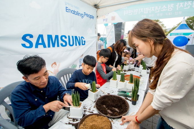 6일 부산에서 열린 '세상모든가족함께 바다 나들이' 행사에 참여한 시민들이 삼성전자 청소년자립지원 사업 소개 부스에서 화분만들기 체험을 즐기고 있다. 사진=삼성전자