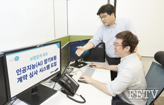 삼성화재 직원들이 인공지능 시스템을 보면서 대화하고 있다. (사진=삼성화재)