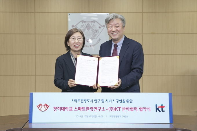 윤혜정(왼쪽) KT 빅데이터사업지원단장 전무와 정남호 경희대학교 스마트관광연구소 소장이 업무 협약을 맺고 기념촬영을 하고 있다. 사진=KT