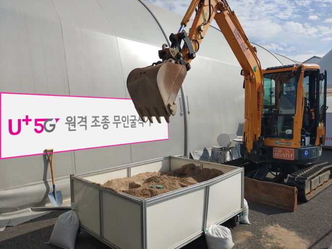 성남 서울공항 전시장 밖에 마련된 작업장에서 5G 무인 굴삭기가 시연을 펼치는 모습. 사진=LG유플러스