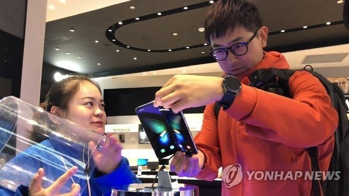 지난 8일(현지시간) 중국 상하이 번화가 난징둥루에 있는 삼성전자 플래그십 매장에서 고객이 전시된 갤럭시폴드 실물을 살펴보고 있다. 사진=연합뉴스