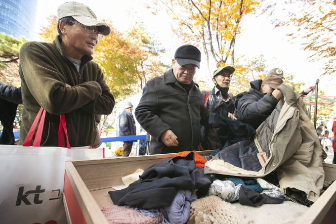 동자동 주민들이 28일 동자동 새꿈어린이공원에서 열린 방한복 나눔 행사에서 옷을 고르고 있다. 사진=KT