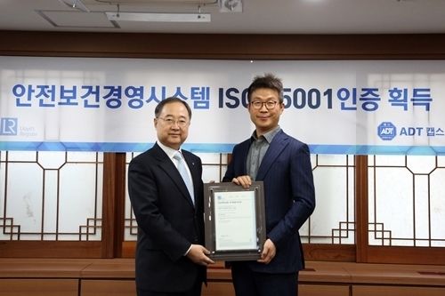 사진=보안전문기업 ADT캡스 최진환 대표이사(우)와 로이드인증원 한국지사 유상근 대표(좌)가 ISO 45001 인증 획득 기념촬영을 진행하고 있다.(제공 : ADT캡스)