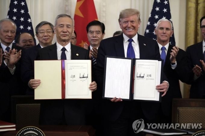 도널드 트럼프(오른쪽) 미국 대통령과 류허 중국 부총리가 15일(현지시간) 미국 워싱턴DC 백악관에서 미중 1단계 무역 합의안에 서명한 뒤 이를 들어보이고 있다. 사진=연합뉴스