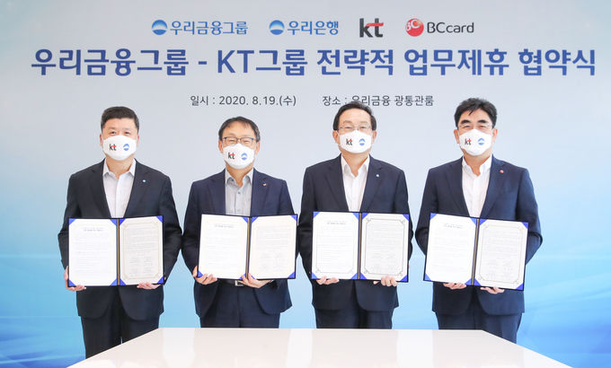 우리금융그룹은 19일 서울 중구에 위치한 우리은행 본점에서 KT그룹과 업무협약을 맺었다. 손태승 우리금융 회장(왼쪽에서 세번째)과 구현모 KT그룹 대표이사(왼쪽에서 두번째) , 권광석 우리은행장(왼쪽에서 첫번째), 이동면 BC카드 사장(왼쪽에서 네번째)이 기념촬영을 하고 있다.