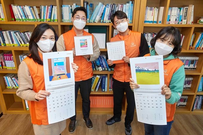 한화그룹이 점자달력 제작 21주년을 맞아 한화봉사단 임직원들이 점자달력을 소개하며 기념촬영 하고 있다.(사진=한화그룹)