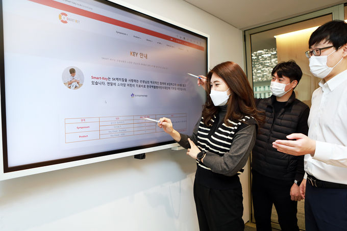 SK케미칼 구성원들이 의료정보 플랫폼 '스마트키'의 컨텐츠를 살펴보고 있다. 이 플랫폼의 컨텐츠 이용량은 기부금으로 적립돼 백혈병 환우에게 전달된다.(사진=SK케미칼)