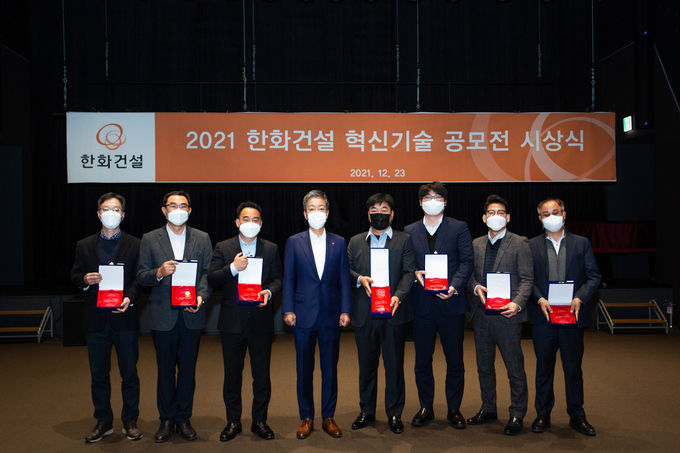 한화건설이 23일 진행한 ‘2021 한화건설 혁신기술 공모전’ 시상식에서 대상을 수상한 유석토건(주) 김명원 대표(우측에서 네번째), 한화건설 윤용상 건축사업본부장(좌측에서 네번째) 및 수상자들이 기념촬영을 하고 있다. 제공=한화건설