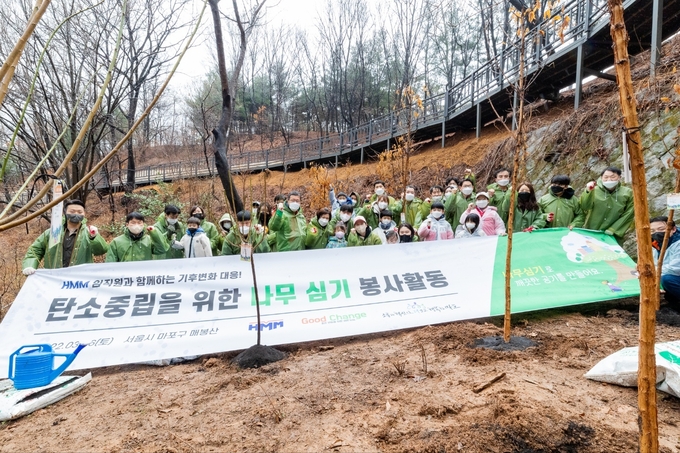 지난 26일 마포구 상암동에 위치한 매봉산 근린공원에서 HMM 임직원과 가족 50여명이 기후변화 대응과 탄소중립을 위한 나무심기 봉사활동을 진행하고 있다.(사진=HMM)