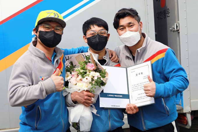김병용(오른쪽) CJ대한통운 상무, 택배기사 길현철(가운데)씨, 경북성주 집배점장 신현철씨가 함께 시상식 이후에 기념사진 촬영을 하고 있다.(사진=CJ대한통운)