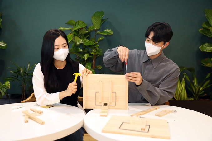 현대글로비스 직원들이 어린이에게 선물할 독서대를 직접 제작하고 있다.(사진=현대글로비스)