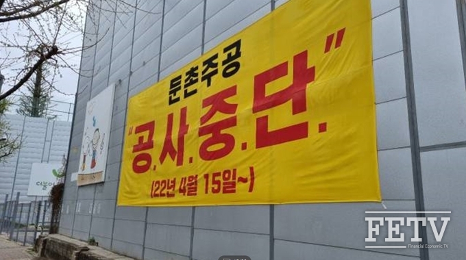 둔촌주공 공사 현장에 걸린 공사중단 현수막. 사진=김진태 기자