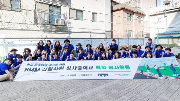 지난 5월 31일 마포구 성사중학교에서 진행된 ‘교육환경 개선을 위한 HMM 신입사원 벽화 그리기 봉사활동’에서 신입사원들이 완성된 벽화 앞에서 기념 촬영을 하고 있다.(사진=HMM)