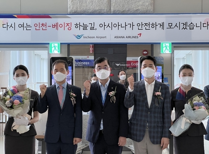 아시아나항공 두성국(중앙) 여객본부장, 아시아나항공 현일조(왼쪽 네번째) 서비스본부장, 인천공항공사 김범호 미래사업본부장이 승무원들과 기념 촬영을 하고 있다. 제공=아시아나항공
