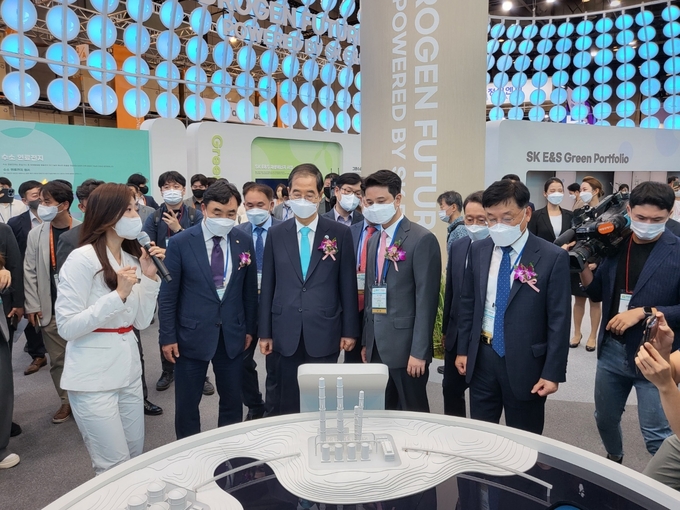 한덕수 국무총리가 H2 MEET 2022 SK E&S 전시관을 방문해 SK E&S 추형욱 대표와 함께 설명을 듣고 있다.(사진=SK E&S)