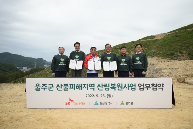 26일 울산 울주군 대복리 산불피해 현장에서 열린 ‘SK 울산 행복의 숲’ 조성을 위한 업무협약식 (왼쪽부터) 유재영 SK이노베이션 울산CLX 총괄, 이순걸 울주군수, 김두겸 울산광역시장, 김준 SK이노베이션 부회장, 이성훈 SK이노베이션 노조위원장, 조경목 SK에너지 사장이 기념촬영을 하고 있다.(사진=SK이노베이션)