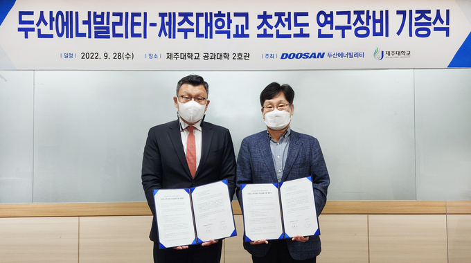 28일 제주대학교에서 열린 ‘두산에너빌리티-제주대학교 초전도 연구장비 기증식’에 참석한 제주대 공과대학 학장인 임종환 교수와 두산에너빌리티 전략혁신부문 송용진 부사장(왼쪽)이 서명 후 기념촬영을 하고 있다. 제공=두산에너빌리티