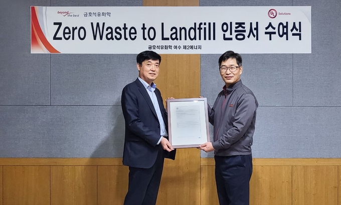 남정우 금호석유화학 안전환경기획실장(왼쪽)과 박재욱 금호석유화학 에너지공장장(오른쪽)이 UL '폐기물 매립 제로' 인증서 수여식에서 기념촬영을 하고 있다.(사진=금호석유화학)<br>
