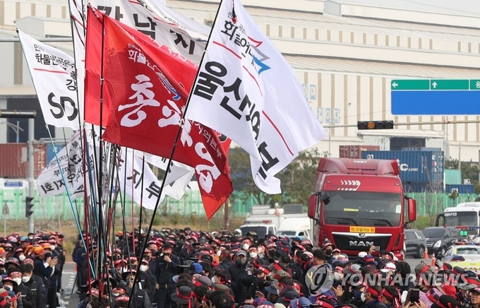 지난 24일 오전 울산신항 앞에서 민주노총 공공운수노조 화물연대본부 울산지역본부의 총파업 출정식이 열리는 가운데 화물차가 지나가고 있다. 사진=연합뉴스