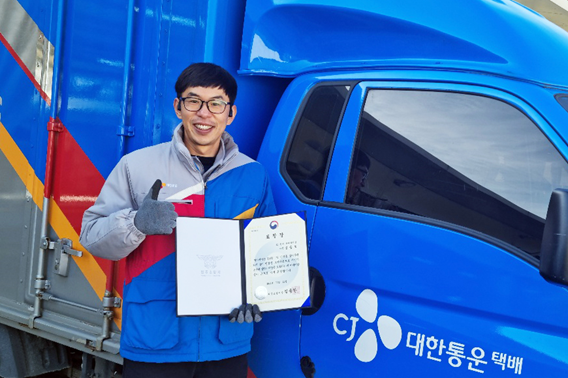 CJ대한통운 택배기사 심승보씨가 소방서에서 받은 표창장을 들고 기념사진 촬영을 하고 있다.(사진=CJ대한통운)