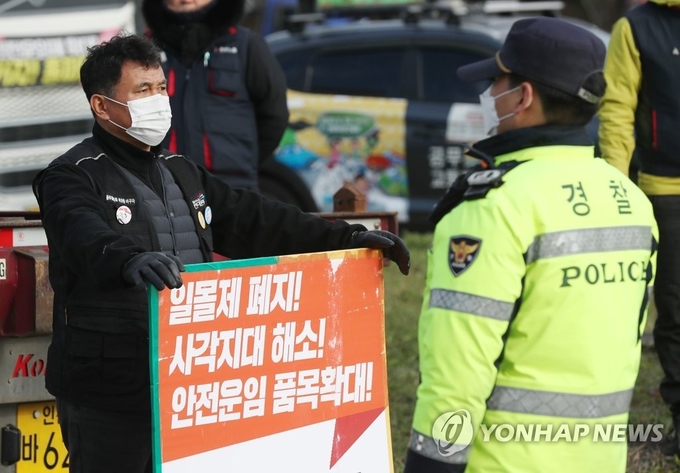 1일 오후 인천시 중구 삼표시멘트 인천사업소 앞에서 화물연대 노조원이 피켓을 들고 경찰관과 대치하고 있다. (사진=연합뉴스)