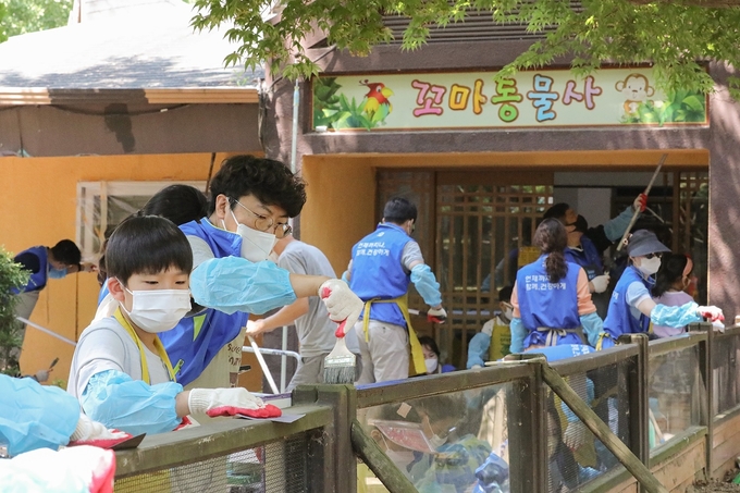동아제약 '세이브투세이브(SAVE2SAVE) 캠페인' 일환으로 올해 6월 실시된 서울대공원 동물원 벽화 그리기 자원봉사활동에서 임직원 가족들이 봉사를 하고 있다.(사진=동아제약)