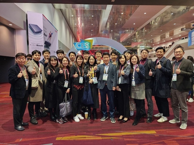 5일 미국 라스베거스에서 개최 중인 CES 2023에 참관한 함영주 하나금융그룹 회장(앞줄 왼쪽에서 7번째)이 함께 참석한 그룹의 젊은 직원들과 기념 촬영을 하고 있다. 사진=하나금융그룹
