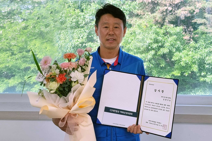 CJ대한통운 택배기사 김흔수씨가 감사장을 받고 기념사진 촬영을 하고 있다.(사진=CJ대한통운)