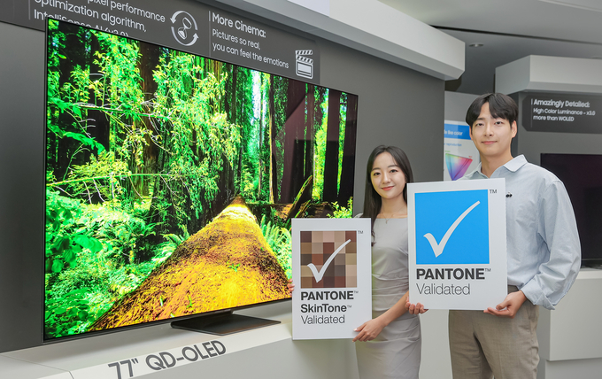 삼성디스플레이 직원들이 TV용 QD-OLED 앞에서 '팬톤 컬러 인증' 및 '팬톤 스킨톤 인증' 로고를 들고 기념 촬영 하고 있다.(사진=삼성디스플레이)