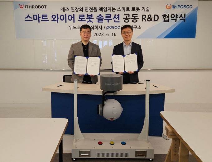 김도윤(오른쪽) 위드로봇 대표이사와 최용준 포스코 기술연구원 공정연구소 로봇솔루션연구그룹장이 스마트 와이어 로봇 개발 협력 체계 구축 업무협약 체결 뒤 스마트 와이어 로봇과 함께 기념촬영을 하고 있다. 사진=포스코