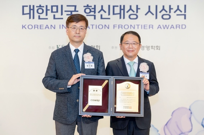 2023 대한민국 혁신대상 시상식에서 (좌측부터) 정선용 코웨이 리빙케어 개발실장과 강명수 한국표준협회장이 기념촬영을 하고 있다.(사진=코웨이)