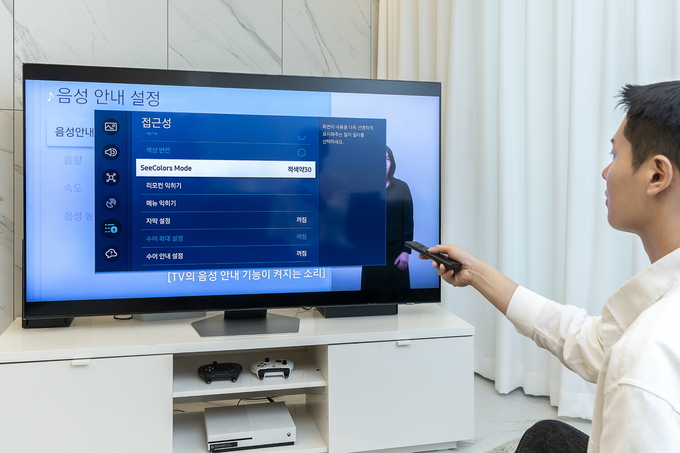 삼성전자 모델이 접근성 기능 '씨컬러스 모드'를 활용해 티비의 컬러 필터를 설정하는 모습(사진=삼성전자)