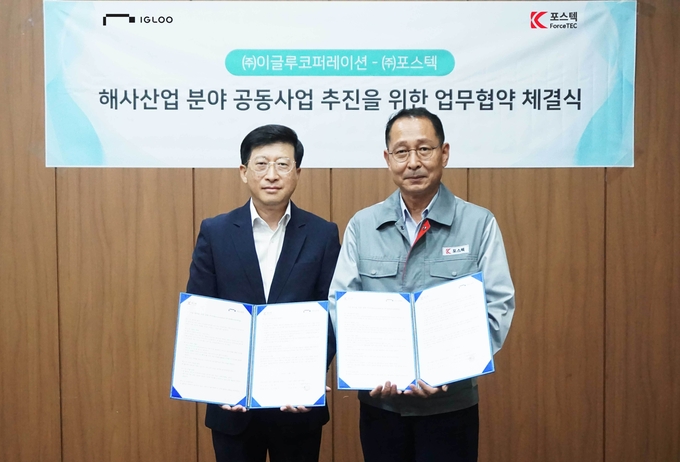 이민섭 이글루코퍼레이션 부사장(왼쪽)과 김상용 포스텍 대표가 5일 경상남도 창원시 성산구에 위치한 포스텍 본사에서 ‘해사산업 분야 공동사업 추진을 위한 양해각서(MOU)’를 체결하고 기념 촬영을 하고 있다.(사진=이글루코퍼레이션)