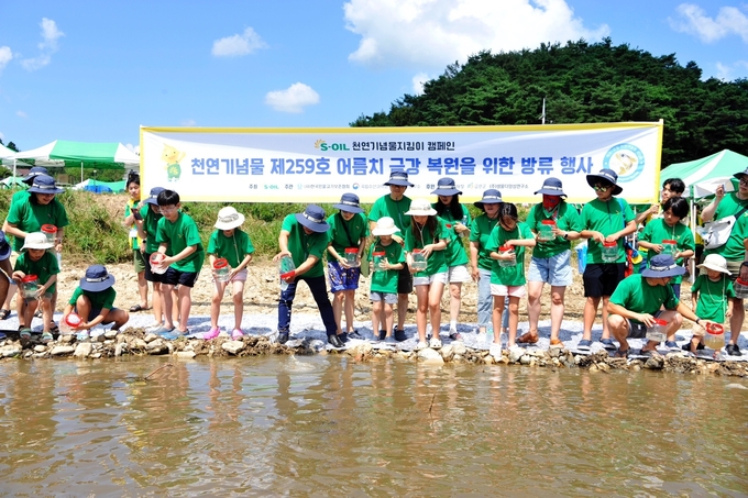 S-OIL 직원 가족들이 19일 충남 금산군 부리면 금강 하천변에서 어름치 치어 방류 활동과 하천 생태체험을 하고 있다.(사진=S-OIL)