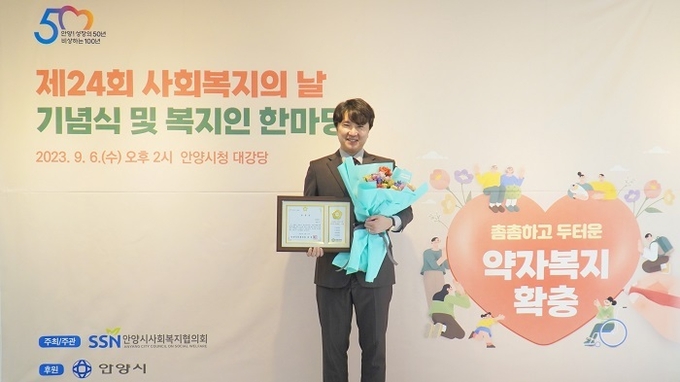 사진=NGO단체 위브릿지 대표이사 김정규가 표창장 수상 기념 사진을 촬영하고 있다.