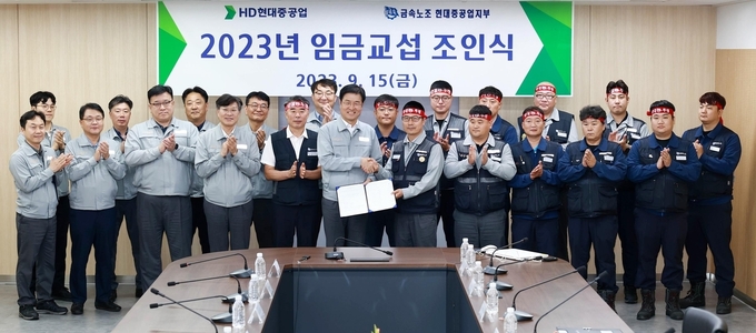 HD현대중공업 노사 관계자들이 15일 울산 본사 조선경영관에서 '2023년 임금협상 조인식'을 개최한 뒤 기념촬영을 하고 있다. 사진=HD현대중공업
