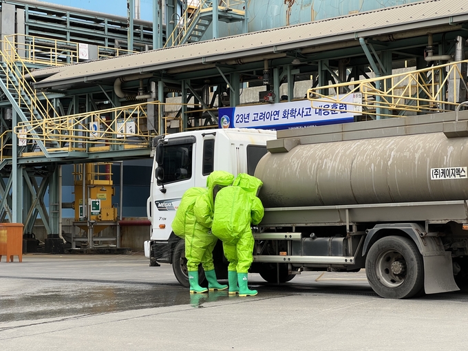 작업자들이 보호복을 입고 황산 누출 부위 긴급 조치 훈련을 실시하고 있다. (사진=고려아연) 