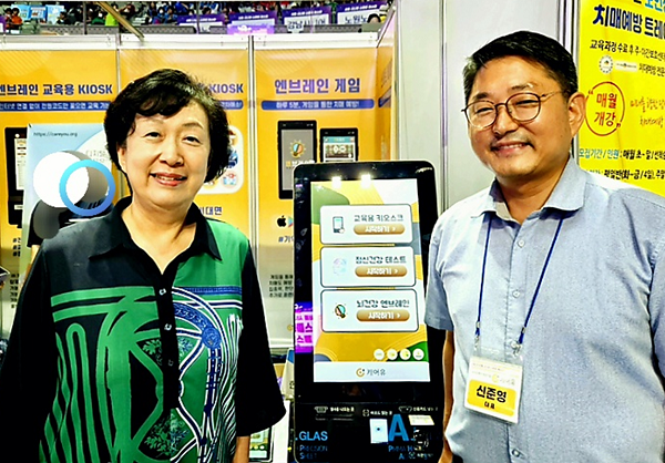 '2023시니어 페스타 행사에 처음 선보인 ‘엔브레인' 24인치 신규 키오스크와 함께한 강남대 박영란 교수(좌)> /사진:캐어유 제공